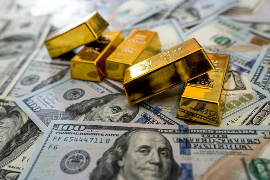 Tumpukan emas di atas uang dollar.